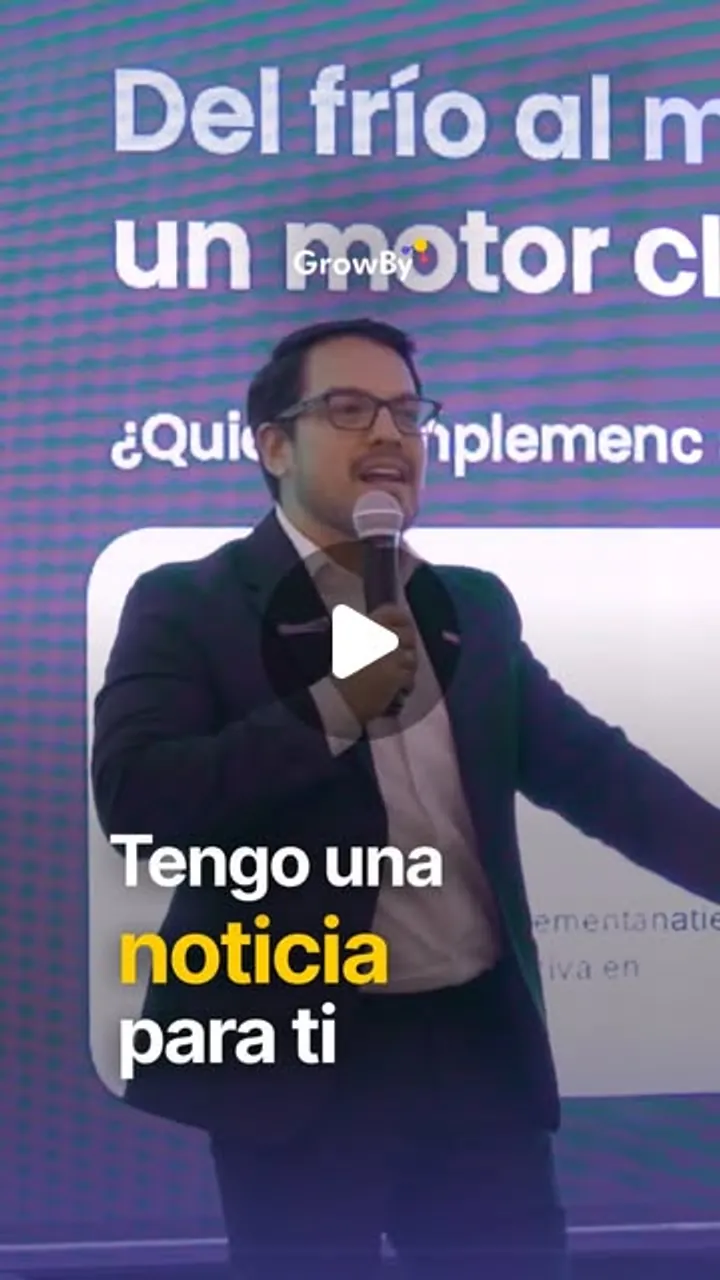 Kevin Yarlequé hablando con micrófono en un escenario, delante de una presentación de GrowBy